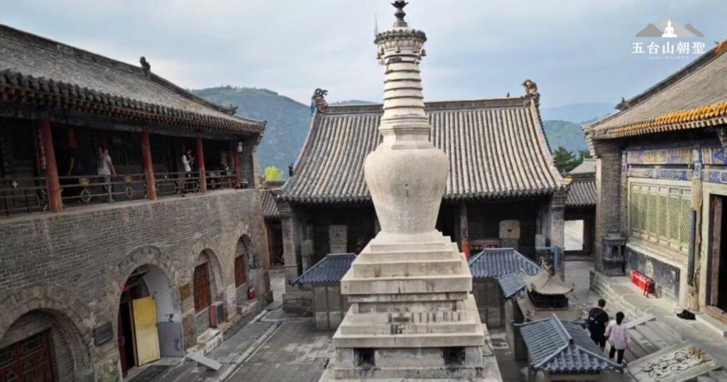 這座白塔位於五台山南山寺內,是當地最具標誌性的佛塔之一。塔身線條流暢,呈瓶形設計,象徵佛教的智慧與慈悲。四周環繞著古色古香的寺院建築,散發著寧靜而莊嚴的氛圍,吸引無數朝聖者與旅人前來參拜與靜修。背景可見青山環繞,襯托出佛門聖地的祥和與靜謐之美。