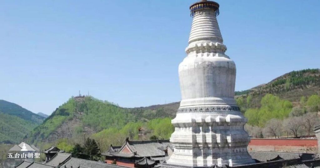 這張圖片展示了五台山塔院寺的白塔,這座白色佛塔又稱為「釋迦塔」,是五台山的象徵性建築之一。塔身宏偉壯觀,與周圍古剎相映成趣,遠處的青山綠意盎然,使整體景觀更顯莊嚴與寧靜。這裡是許多朝聖者與遊客參訪的必經之地,承載著濃厚的佛教文化與歷史意義。