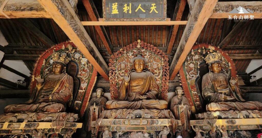 這張照片拍攝於五台山古佛殿,展現了莊嚴肅穆的佛像群。中央佛像結跏趺坐,雙手結印,象徵智慧與慈悲。兩側的菩薩雕像則裝飾精美,展現了唐宋時期的佛教藝術風格。木製結構的屋頂與古樸的彩繪裝飾,使整個殿堂充滿歷史與宗教氛圍,為朝聖者提供靜心修行的環境。