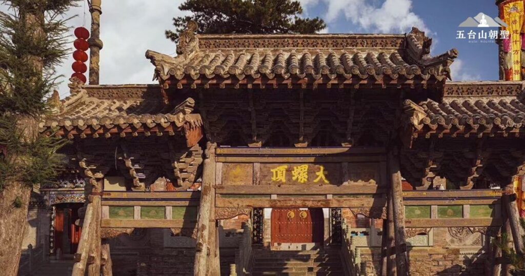 大螺頂寺位於五台山的高處，是重要的朝聖之地，寺廟門楣上刻有「大螺頂」字樣，象徵著登頂圓滿的修行境界。建築以古樸木結構為主，展現歲月的痕跡，門前的扶木則顯示其長久的歷史風霜。這裡是五台山五大台頂之一，朝聖者多選擇登頂參拜，祈願修行圓滿，特別適合尋求內心寧靜與修行成就的信眾。