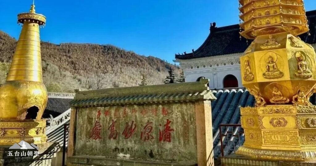 這張圖片展示了五台山顯通寺的一角，畫面中可見金色佛塔與刻有「清涼勝境」字樣的石碑，背景則是連綿起伏的山脈與古樸的寺院建築。清涼寺是五台山的重要佛教道場之一，以莊嚴的建築和深厚的宗教氛圍聞名，是朝聖者與修行者心靈淨化之地。