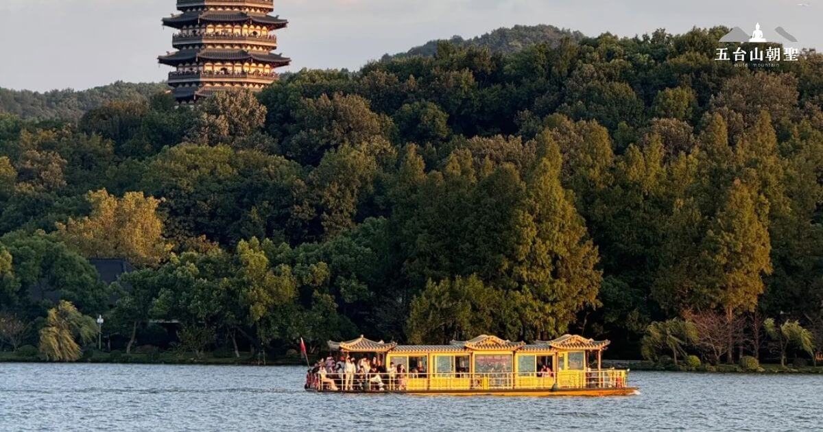 這張圖片展示了在浙江杭州的西湖（West Lake）上進行的船遊。船隻載著遊客，穿行於湖水之中，遠處是著名的雷峰塔。西湖的景色四季如畫，是中國最具代表性的旅遊景點之一。湖岸兩側的翠綠樹木與山脈相依，為遊客提供了優美的自然景觀。