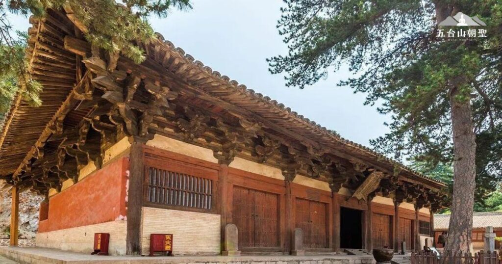 這張圖片展示了五台山佛光寺東大殿的外觀，這座寺廟建於唐大中十一年（公元857年），是目前中國第二古老的木結構建築，僅次於南禪寺。其古樸的建築風格與周圍蒼鬱的松柏相互映襯，營造出寧靜莊嚴的氛圍。