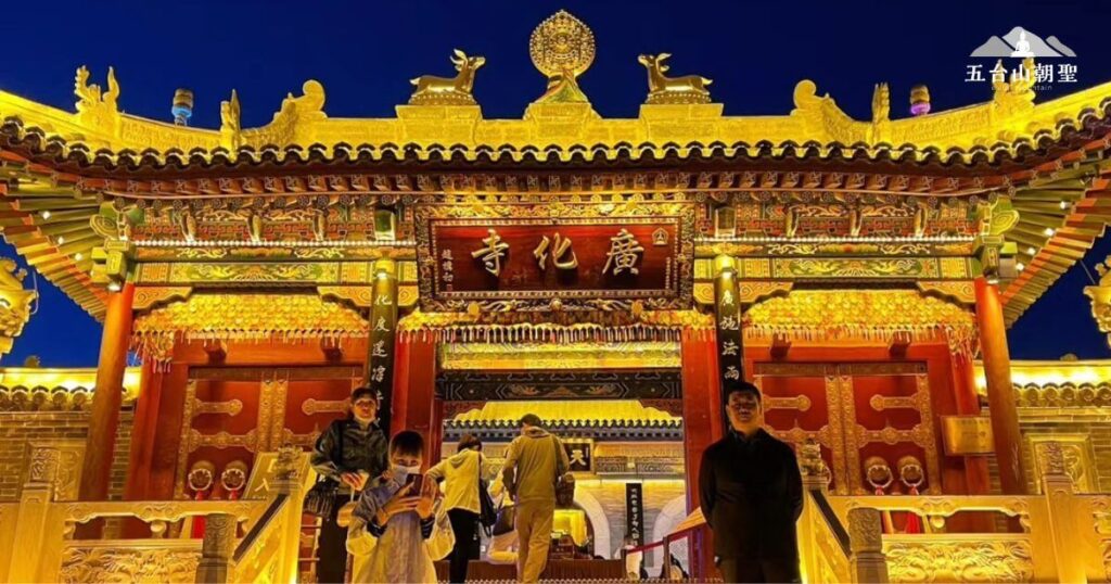 這張照片拍攝於五台山著名的廣化寺,夜幕低垂時金碧輝煌的建築散發著莊嚴與神聖的氛圍。寺廟的屋簷裝飾華麗,燈光映照出古色古香的細緻雕刻,門口牌匾上寫著「廣化寺」。寺前有朝聖與參訪的信徒,展現這座千年佛教聖地的虔誠與活力。