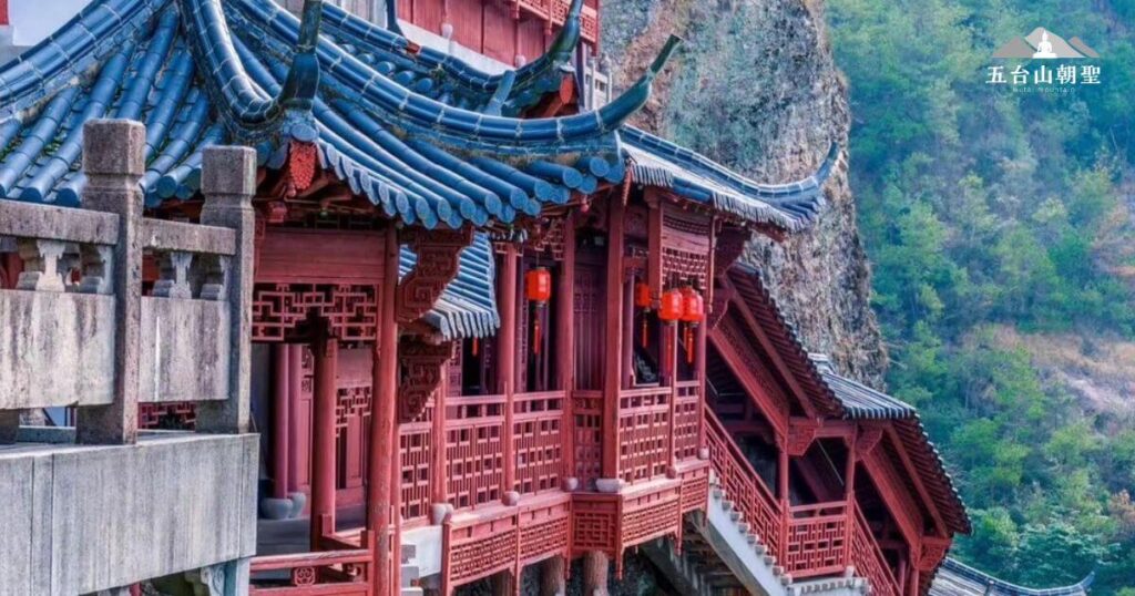 這張照片展現了五台山懸空寺的近距離視角,讓人驚嘆於這座千年古剎的精細工藝與獨特結構。紅色木製廊道與藍色琉璃瓦交錯,與懸崖峭壁融為一體,展現中國古代建築的高超技藝。懸空寺懸掛於半山腰,依靠數根木樁支撐,看似懸於空中卻穩固無比,是世界罕見的懸空建築,也是信仰與文化的結晶。