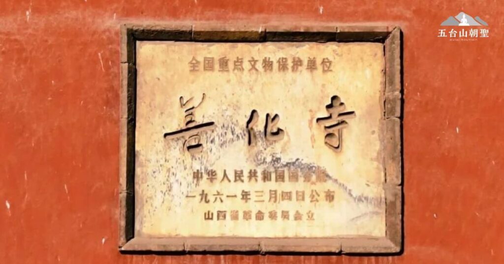這張圖片展示了五台山善化寺的文化保護標誌牌匾,說明該寺被列為「全國重點文物保護單位」。牌匾上記載了公告日期為1961年3月4日,由中華人民共和國國務院公佈,山西省革命委員會立碑。這塊標誌性的石碑嵌入紅色牆面,歷經歲月洗禮,字跡依然清晰,象徵著善化寺作為歷史文化遺產的重要地位,也反映了中國對佛教古蹟的保護與重視。