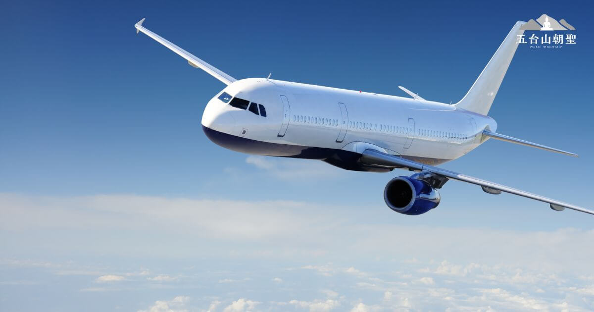 這張圖片展示了一架飛機在藍天白雲間飛行,象徵旅程的開始與順利抵達五台山。飛機的流線設計與乾淨的機身展現現代航空的安全與舒適感。圖片右上角印有「五台山朝聖」的標誌,表明這是前往五台山的航班宣傳或旅遊資訊圖片,適合用於介紹從各地搭機前往五台山的交通方式。