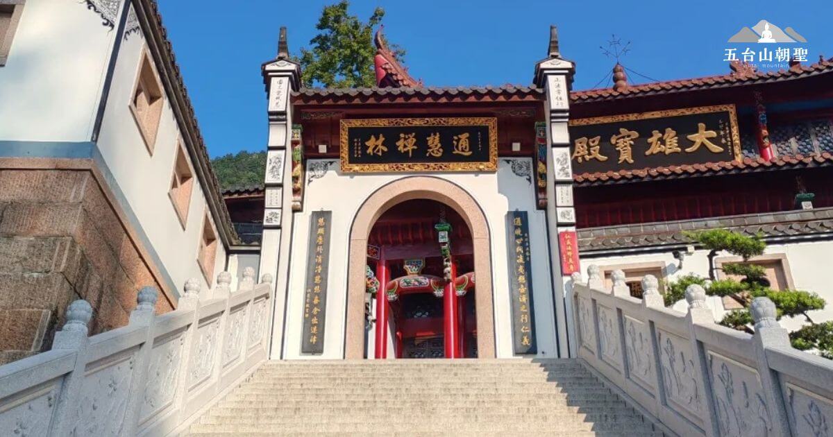 這張圖片展示了通慧禪林（Tonghui Zen Forest）大殿的壯麗入口。寬敞的石階通往寺廟的大門，門額上寫著「通慧禪林」字樣，兩側的石柱上刻有精美的傳統書法。禪林內景色清幽，造型獨特，彰顯了古老的禪宗文化與智慧的力量。