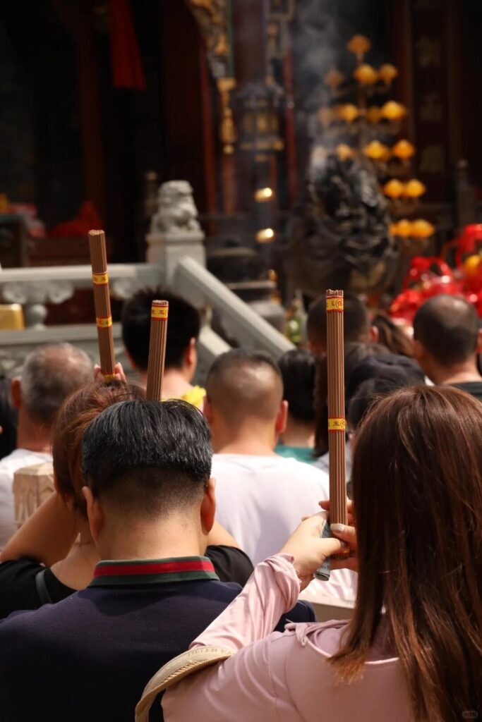 圖片展示了朝聖者在五台山（Mount Wutai）朝聖期間，虔誠地手持香火參拜的景象。畫面中的信徒依次站立，雙手高舉香火，向佛像祈求庇佑與祝福。煙霧繚繞，呈現出一種神聖與敬畏的氛圍，象徵著朝聖者的虔誠心願和對佛法的尊崇。